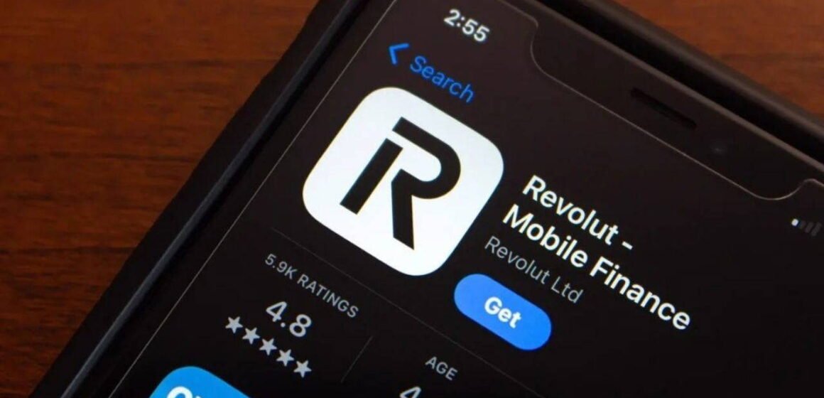 Akıllı telefonda açık Revolut uygulaması ve yanında duran çoklu para birimi destekli kart